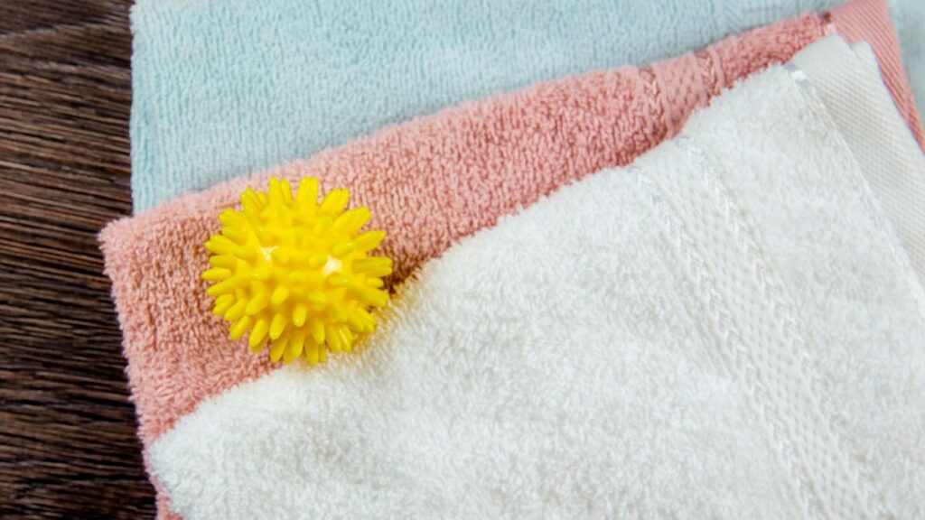 Bottle of apple cider vinegar for folded fresh laundry.