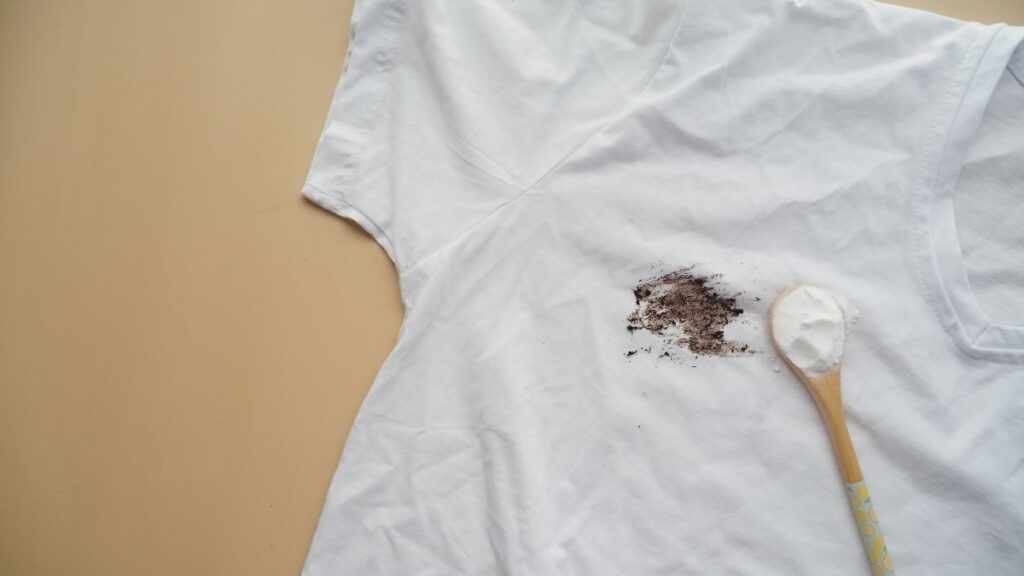 Applying baking soda paste to remove stains from white shirt.