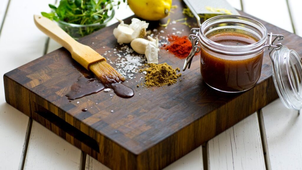 Bowl of apple cider vinegar marinade with herbs and garlic cloves.