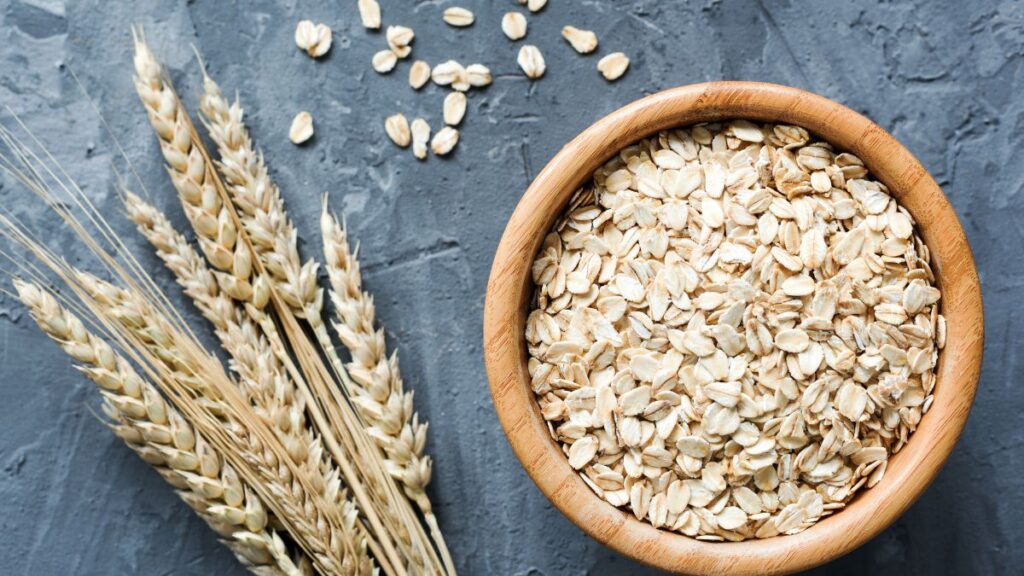 Rolled oats in a bowl placed on a grey surface.