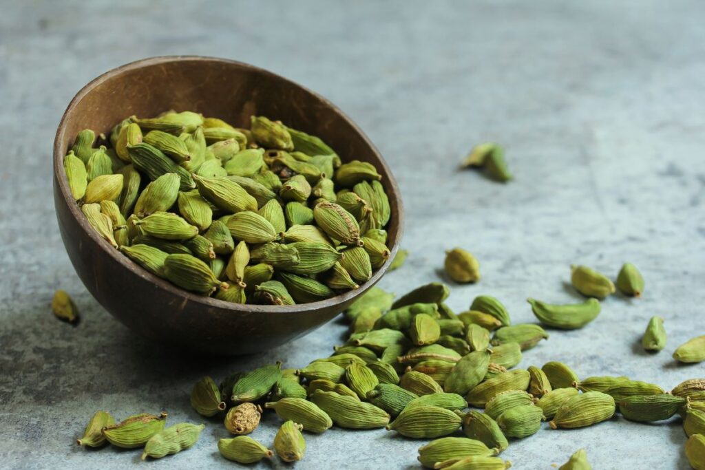 Green cardamom pods in a small bowl.
