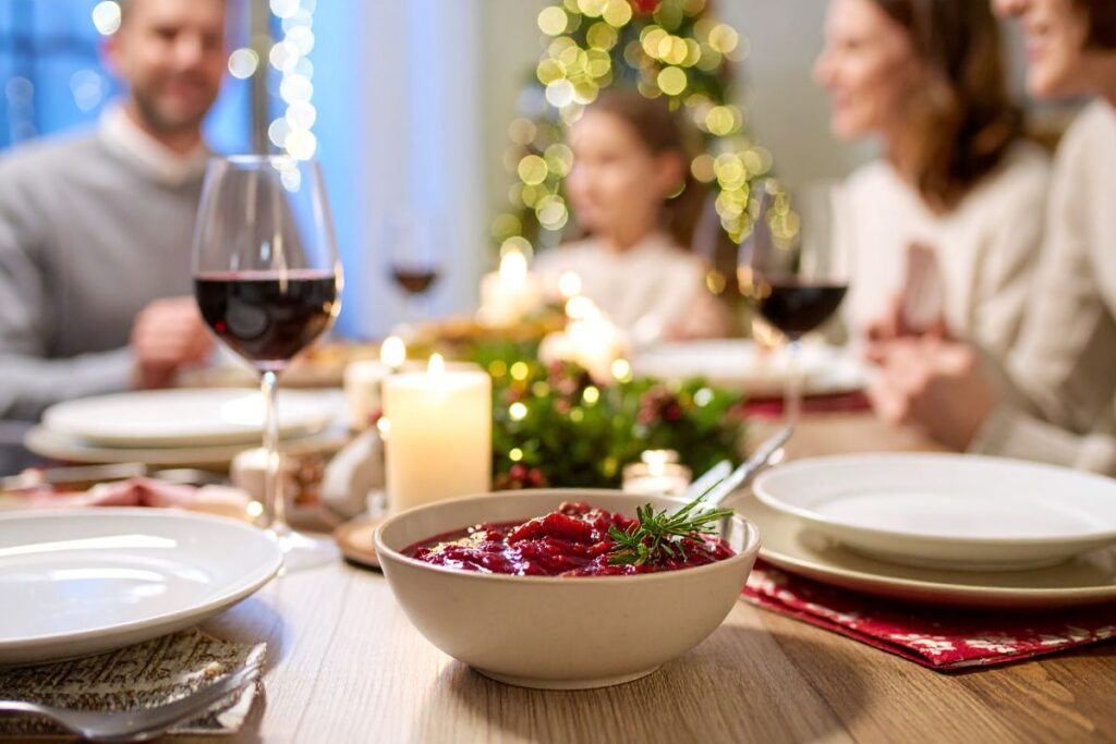 Warm family dinner table with candles and holiday food.