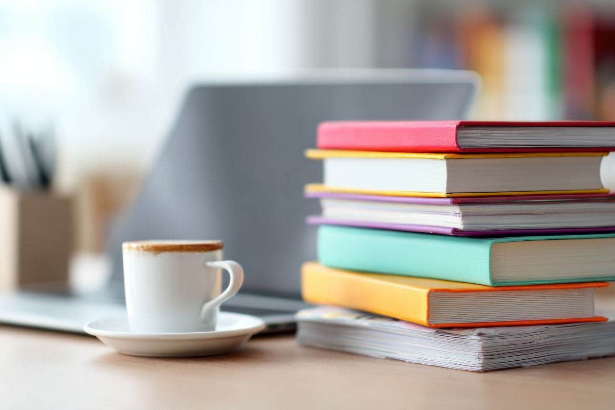 Minimal desk with coffee and books for a calm workday.