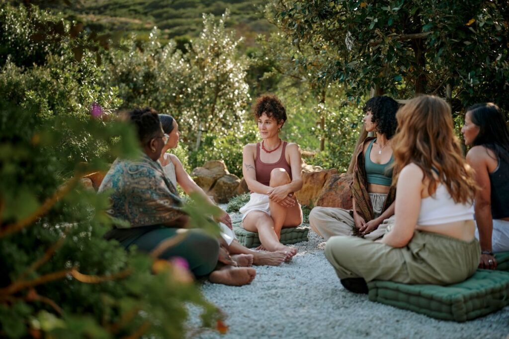 Group of women sitting outdoors sharing quiet conversation.