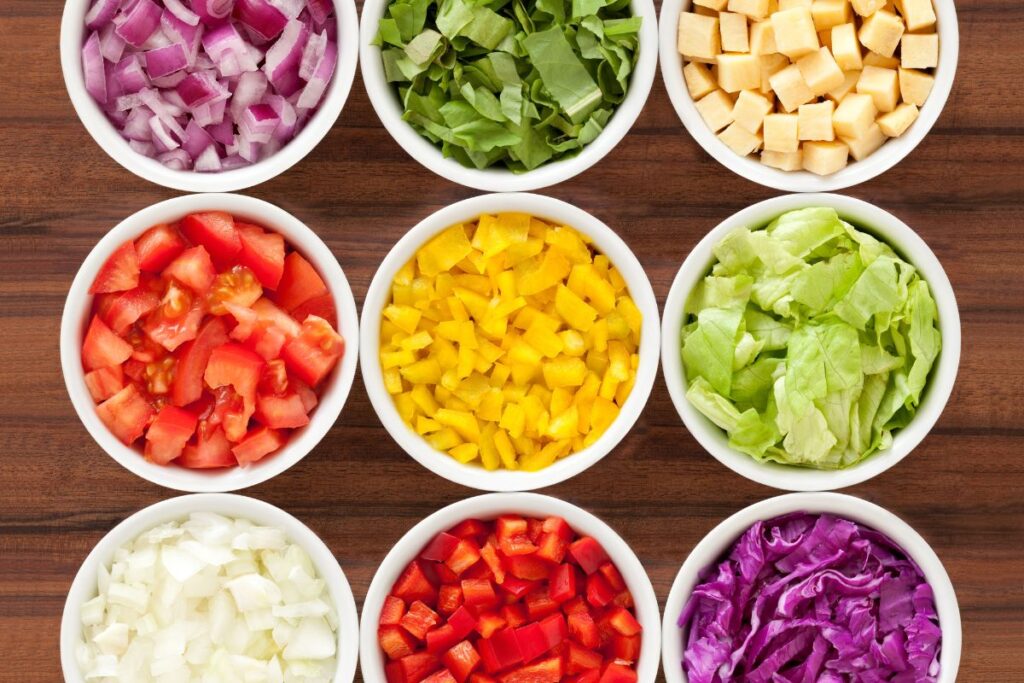 Colorful bowls of chopped vegetables prepared for holiday cooking and meal prep.
