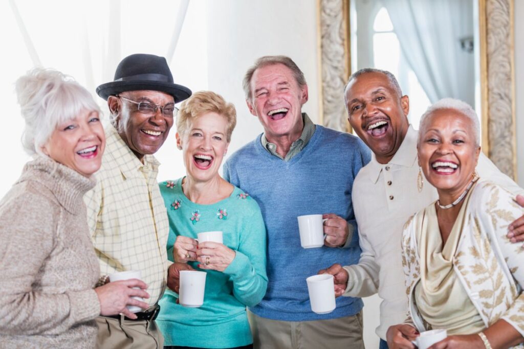 Group of friends over 50 laughing and connecting over coffee together.
