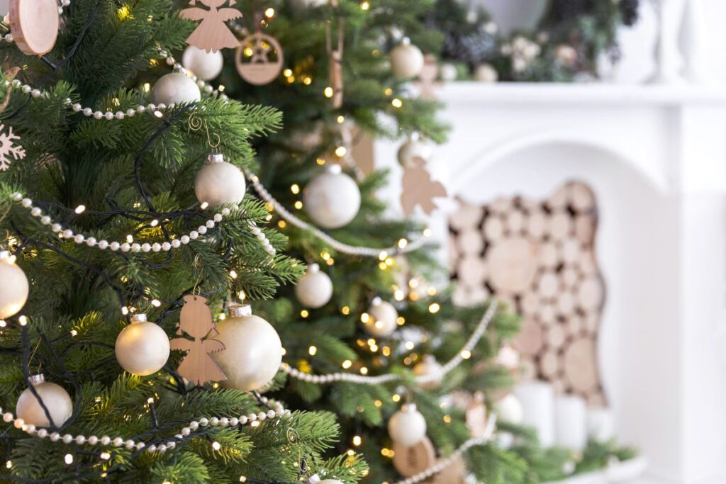Decorated Christmas tree with gold ornaments and string lights in cozy home.