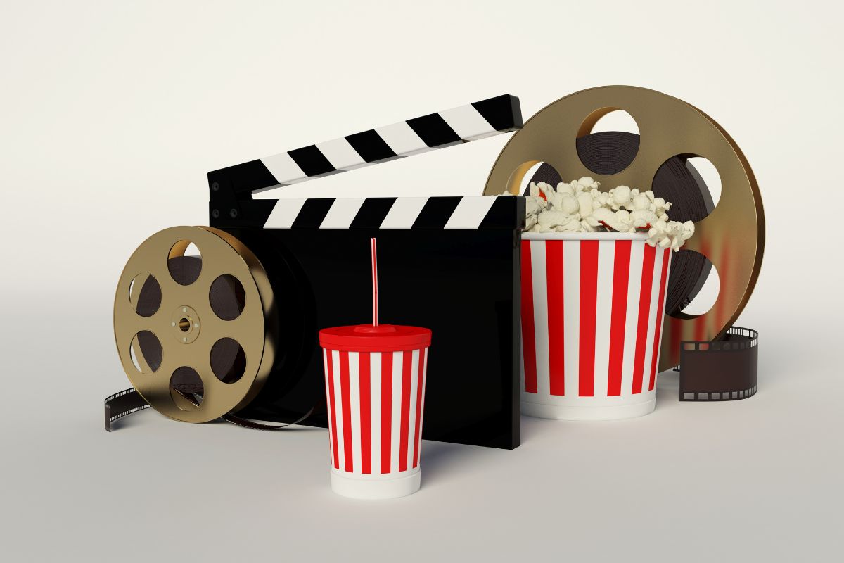Classic movie night setup with popcorn, film reels, and a clapperboard.