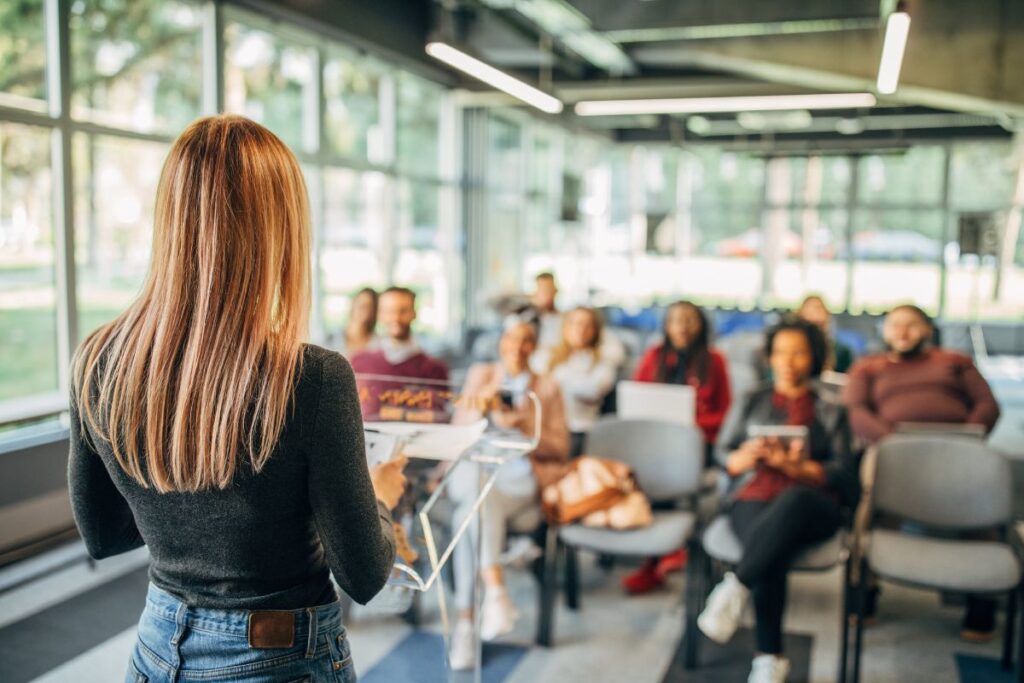 Woman presenting to audience in bright modern office space.