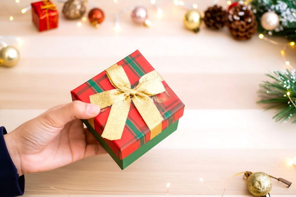 Sharing kindness with a wrapped Christmas gift decorated in red and gold.
