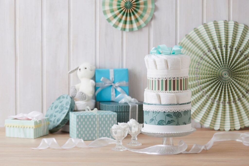 Elegant neutral diaper cake centerpiece with gifts and pastel décor on a wooden table.
