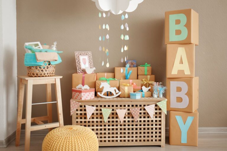 Baby shower setup with pastel gifts, BABY block décor, and hanging cloud decor.
