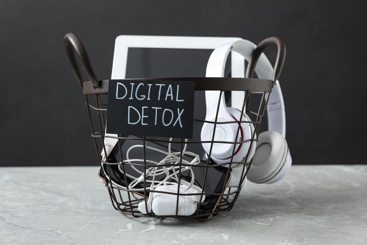 Basket filled with headphones, tablet, and phone labeled digital detox.