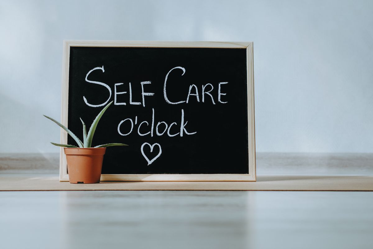 A black board with words "Self Care O'Clock" written using white chalk.
