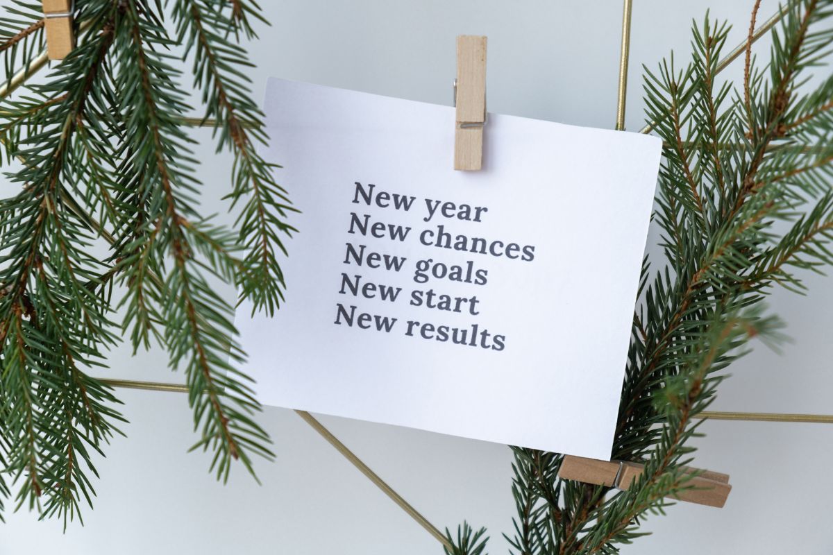 Minimal New Year message card clipped to pine branches with motivational words.