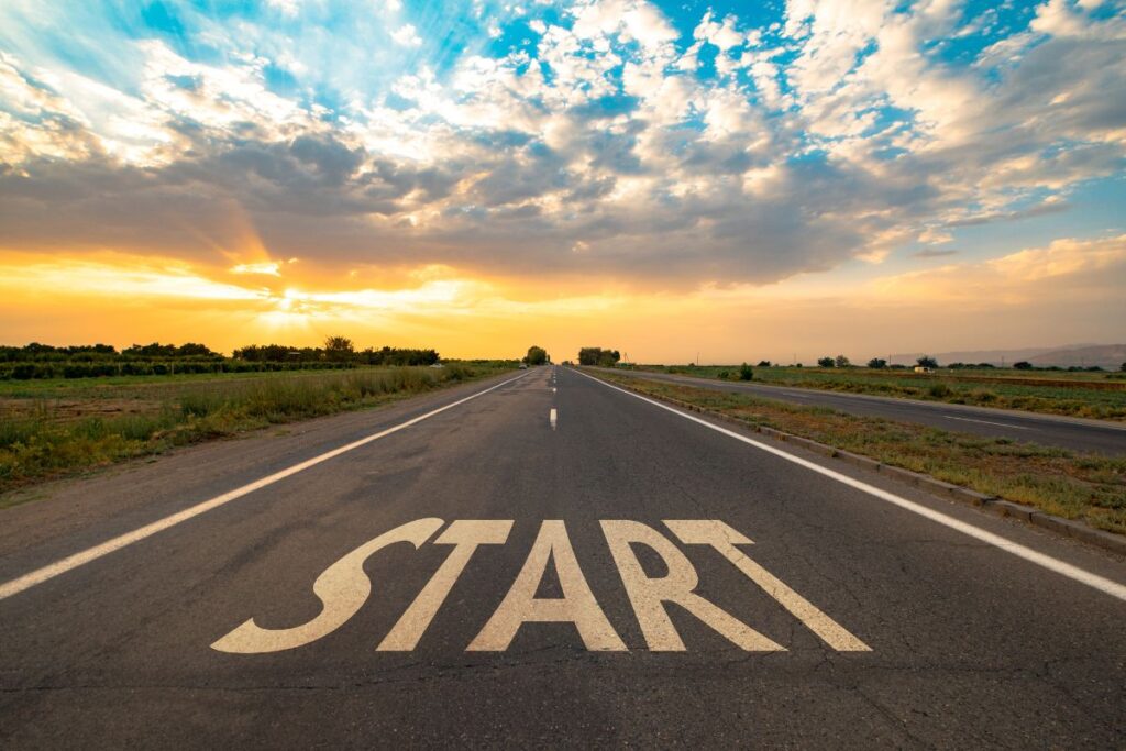 Sunrise over an open road with “START” written on the pavement, symbolizing new beginnings.