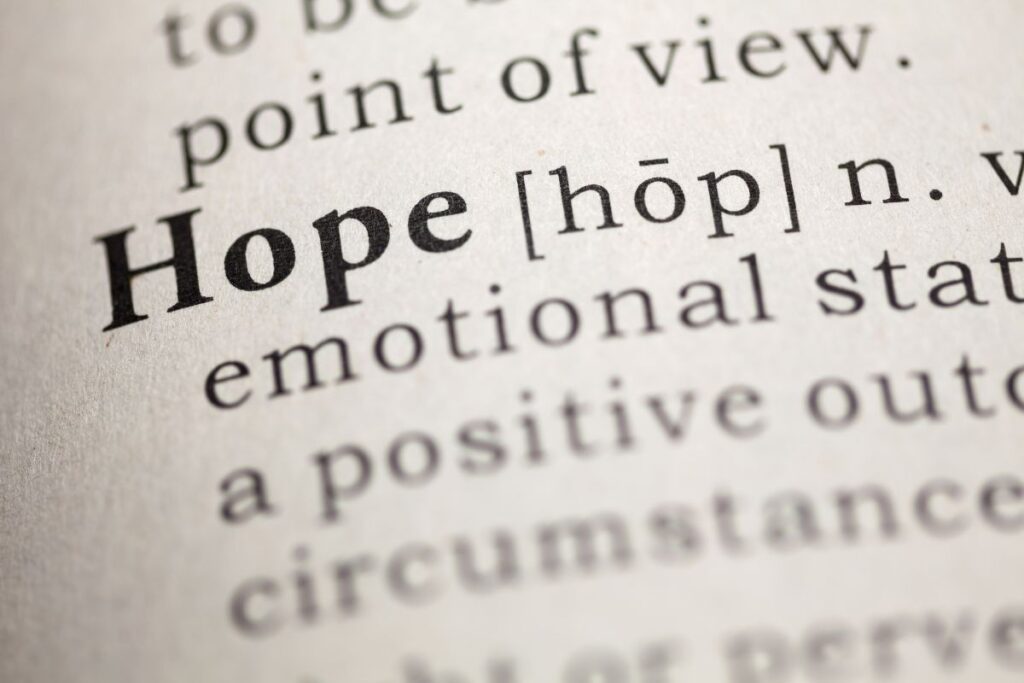 Macro shot of the word “Hope” in a dictionary, representing optimism and forward-looking perspective.