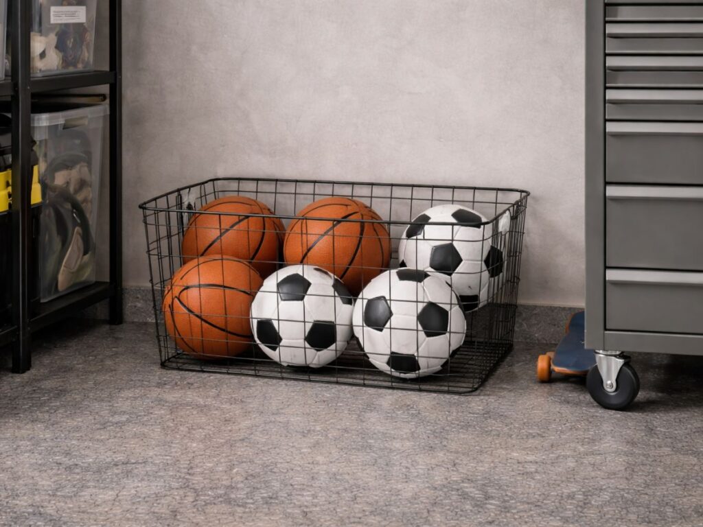 Wire basket neatly stores basketballs and soccer balls in one place.