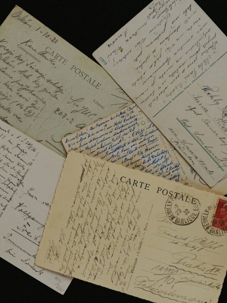 Collection of vintage postcards with handwritten notes spread out.