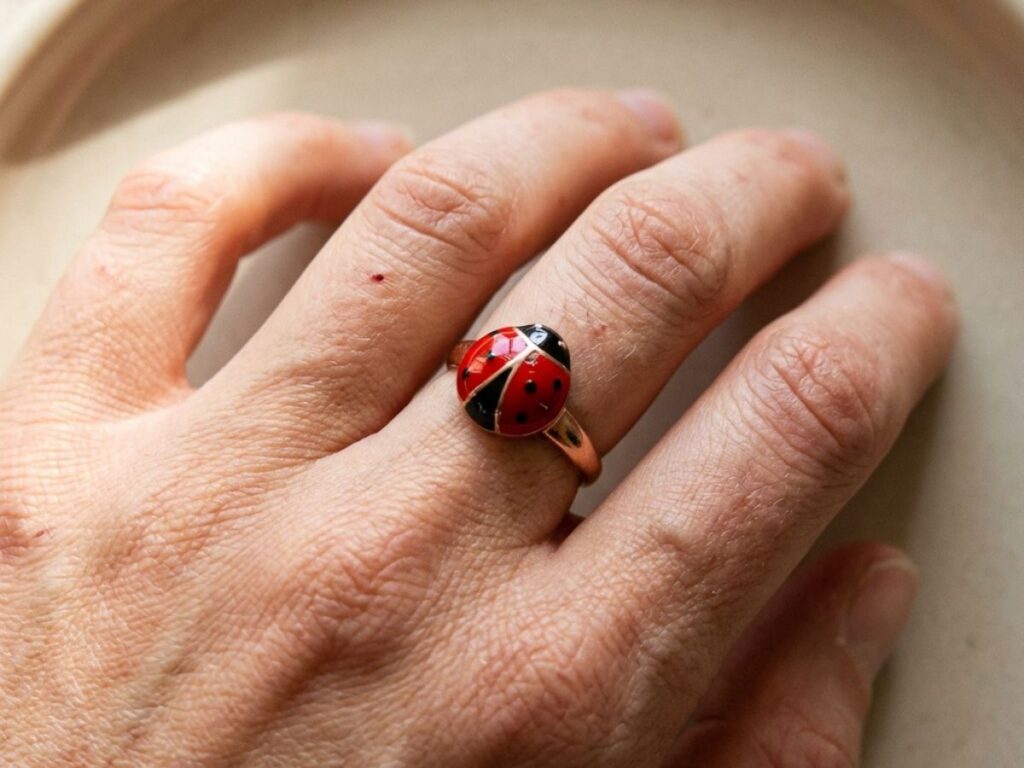 Hand wearing red ladybug ring close-up
