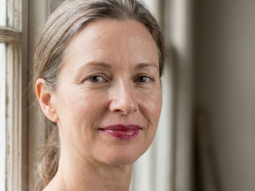 Mature woman with berry lipstick and natural makeup by window