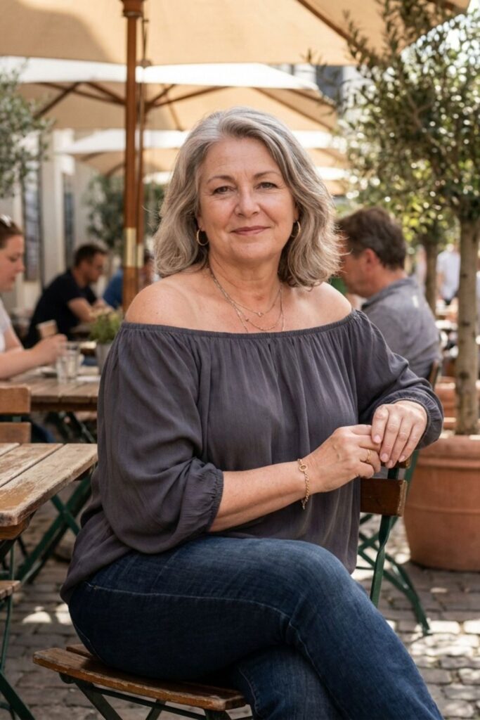 Plus size woman in off shoulder top sitting at café patio