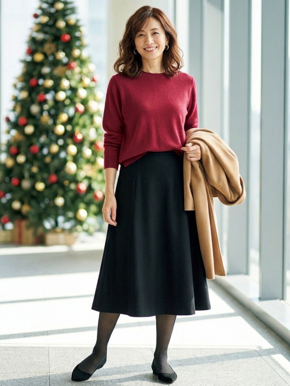 Woman in a cranberry sweater tucked into a black midi skirt with black tights and pointed flats